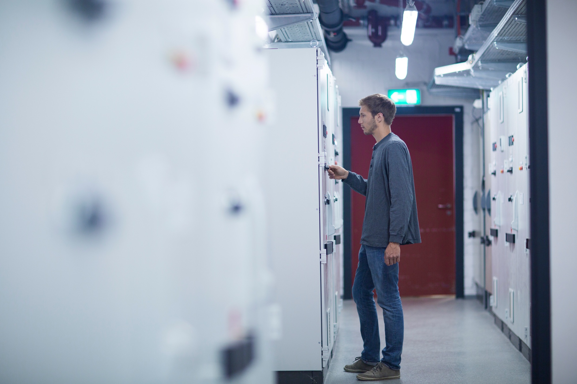 Male technician turning switch on in technical room